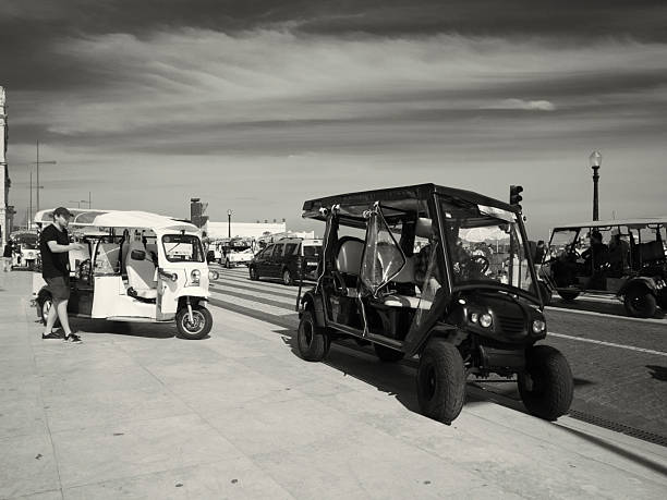 Lisbon, Portugal - June 10, 2023: Tuk-tuk drivers wait for clients at the Praça do Comércio square in Lisbon downtown.