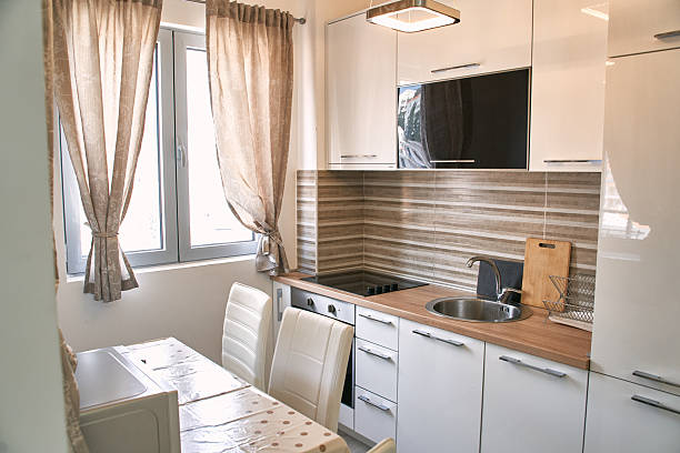 istock Modern minimalist kitchen with white cabinets and natural light from window 2224628963