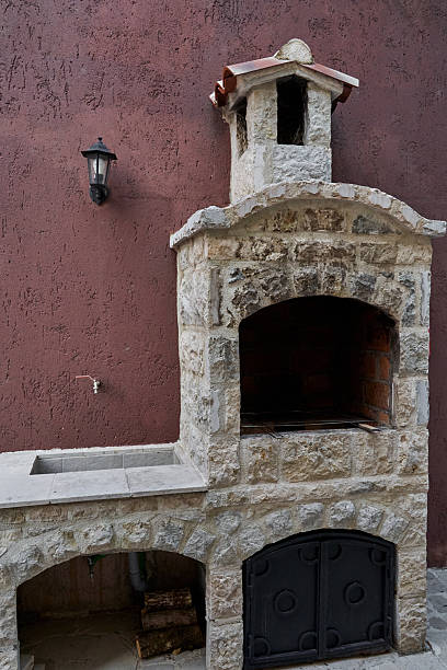istock Rustic stone outdoor barbecue oven with shelf and lantern on textured wall 2224632588