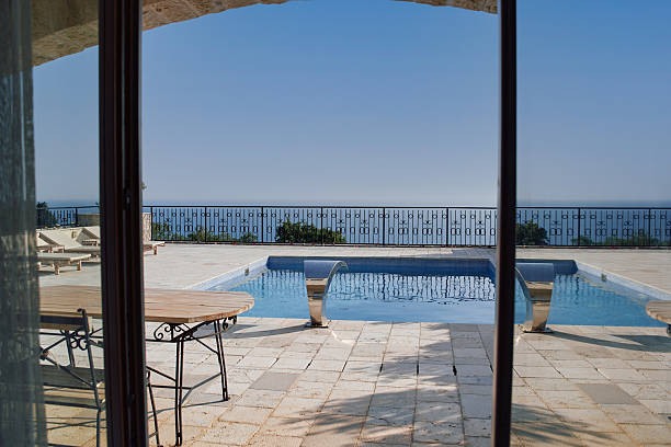 Experience luxury at this villa's poolside oasis, offering stunning ocean views and elegant architectural details. the perfect setting for a tranquil getaway.