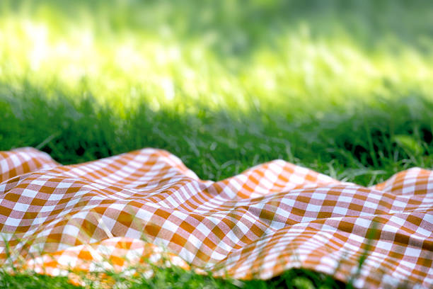 Romantic picnic setting on a haystack with juice, breadsticks, peaches and a straw hat