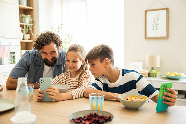 istock Father and kids having breakfast and using smart phone 2224635443