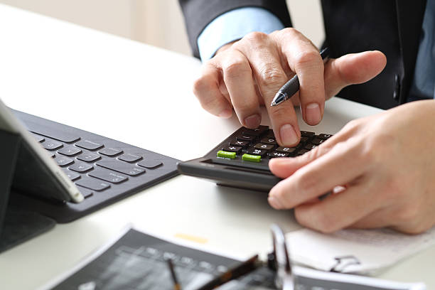 istock Businessman Using Calculator for Financial Analysis at Office Desk 2224635503