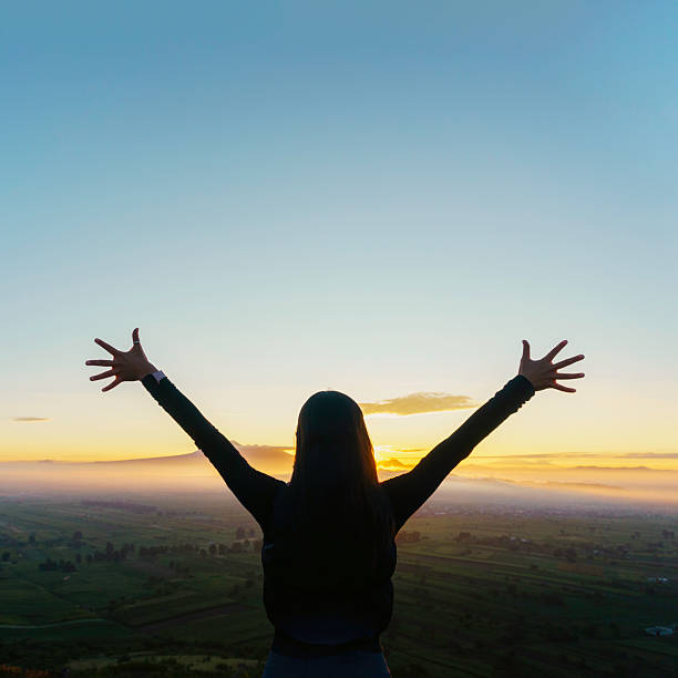 istock Hiker raising arms at sunrise over scenic valley 2224640024