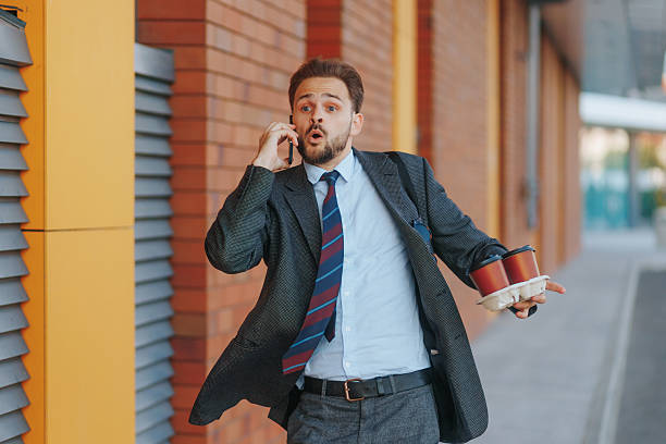 Office man sprinting late to work, juggling phone call and coffee cups