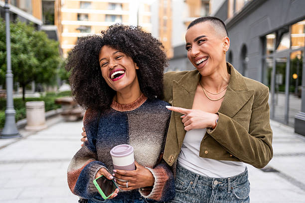 istock Two young women laughing together while walking in the city 2224645148