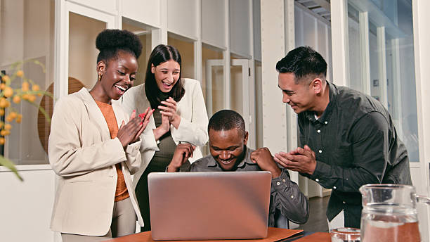 istock Collaborative Business Team Celebrating Success Around a Laptop in a Modern Office Setting 2224645357