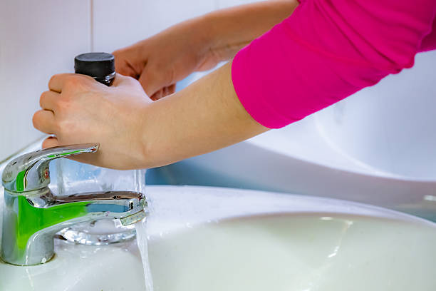 istock Woman is washing her hands in a sink 2224645832