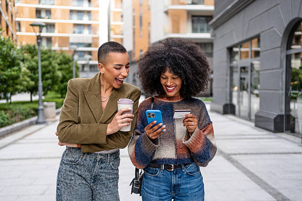 istock Two young women shopping online using a smartphone and credit card 2224646076