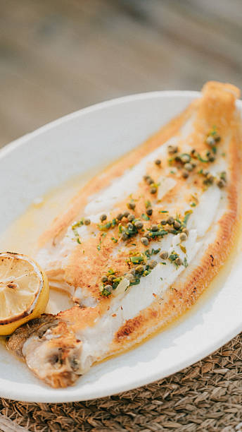 istock A white plate with a fish fillet and a lemon wedge on top 2224649758