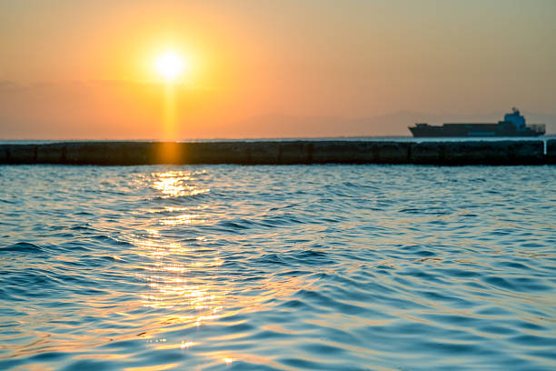 The sea water in the rays of the setting sun and a big ship