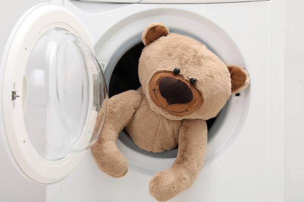 istock Washing machine with teddy bear as background, closeup 2224654326