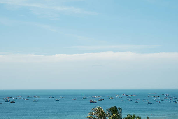 The sparkling blue sea beneath the sun shimmers with a million diamonds, each wave catching the light and reflecting it in a dazzling display.