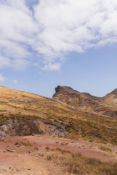 istock Vertical frame of dry rocky hill against bright sky and clouds 2224658740