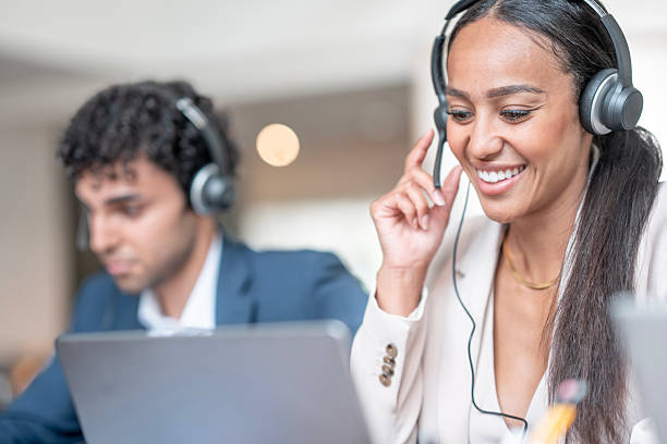 istock Team of Customer Support Representatives Working on Laptops While Wearing Headsets 2224662167
