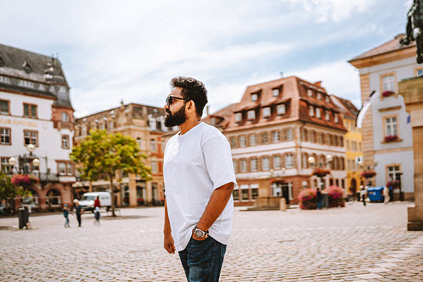 istock Man reflecting in a European town square surrounded by heritage architecture. 2224664572