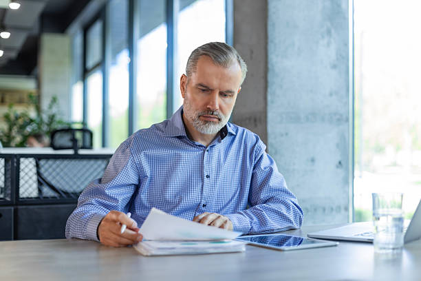 istock Smiling handsome mature businessman manager working office with documents 2224664871