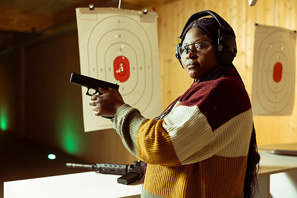 istock Portrait of woman in shooting gallery doing training, practicing with pistol 2224665972