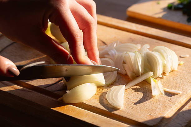 istock hand cutting onion into slices 2224667519