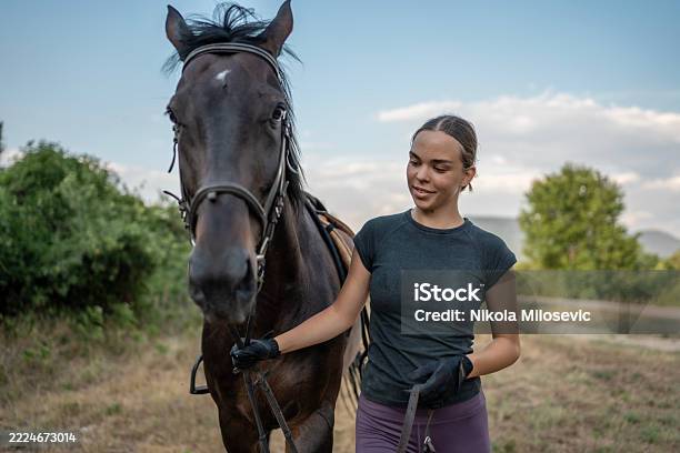 Young Woman Smiling While Standing With A Horse In A Scenic Field - Fotografias de stock e mais imagens de 20-24 Anos