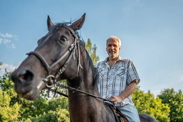istock Mature Man Riding Horse Outdoors on Sunny Day in Natural Setting 2224673056