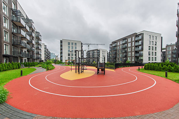 istock Modern Residential Playground with Athletic Track Surrounded by Urban Architecture 2224674098