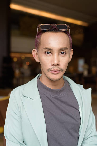 istock Non binary gay man with makeup sitting in cafe 2224677273