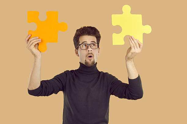 istock Business man holding two jigsaw puzzle parts and thinking about success and system integration 2224678577
