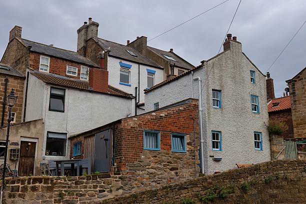 istock A cluster of quaint, closely-packed buildings with various architectural styles under a cloudy sky. 2224680368