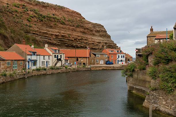 istock A quaint village nestles along a narrow waterway beneath steep cliffs. 2224680383