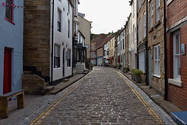 istock A narrow cobblestone street is lined with buildings in an old town setting. 2224680964