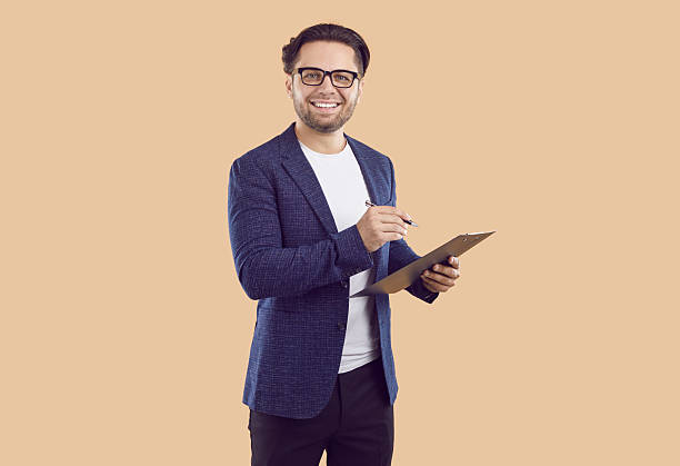 istock Friendly man with clipboard in his hands conducts survey and writes down your answer or choice. 2224683849