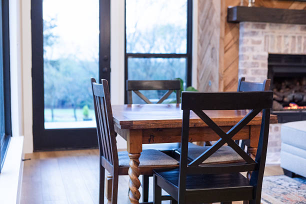 Wooden table with black chairs, a view, hardwood floors. Home interior.