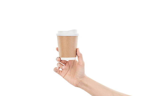 istock Woman's hand holding a paper coffee cup. Takeaway hot beverage, caffeine boost, and morning routine concept. Mockup for brand logo. isolated on white background with clipping path. 2224684490