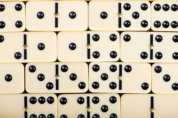 Dominoes, beautiful white domino pieces placed together on a table, selective focus.