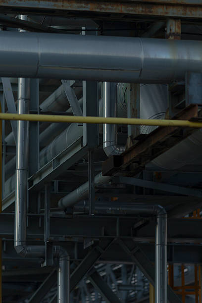 In a large factory, numerous pipes are intricately interconnected to form an extensive network for various operations and functions