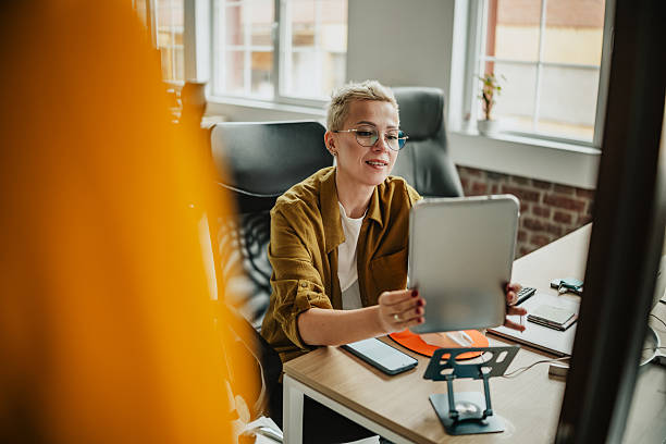 istock Woman engaged in video call while working in modern office during daylight hours 2224693221