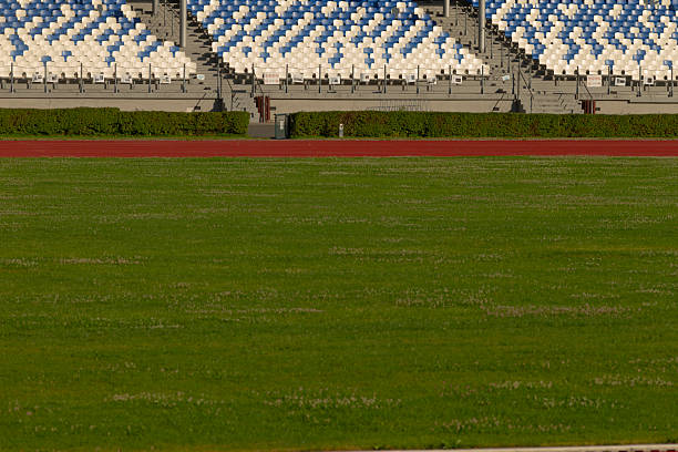 istock An empty stadium with blue and white seats and a red racing track 2224696197