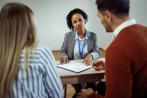 istock Couple discussing contract with real estate agent in empty apartment 2224697793