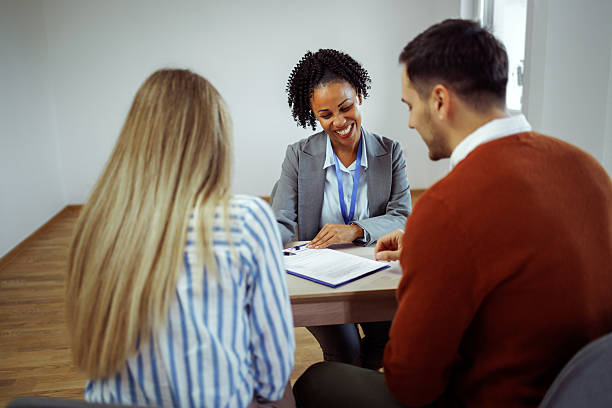 istock Couple discussing contract with real estate agent in empty apartment 2224697819