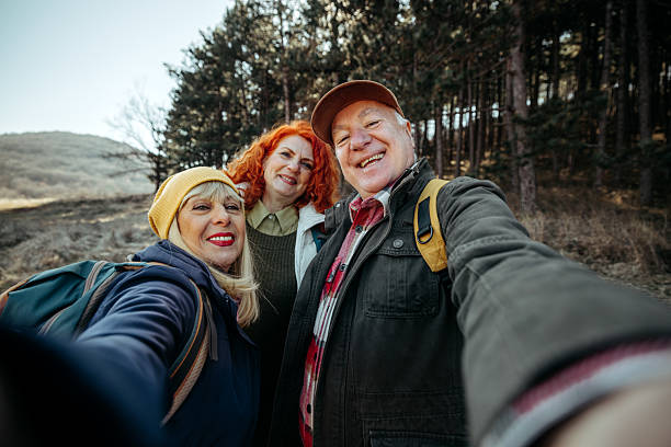istock Three cheerful senior friends taking selfie while hiking in nature 2224697825