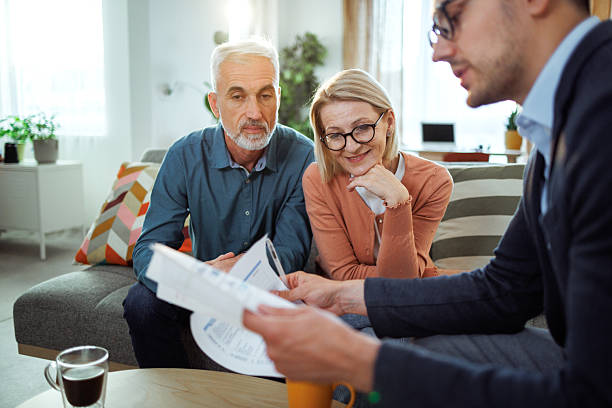 istock Insurance agent discussing policy with mature couple at home 2224698287
