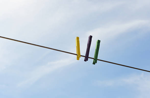Closeup of homemade and hand painted wood clothespins on a clothesline in the sunshine.