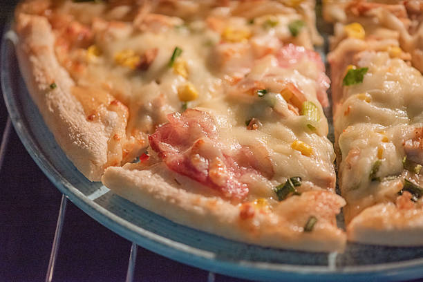 Ready-made pizza with bacon and cheese on a blue plate
