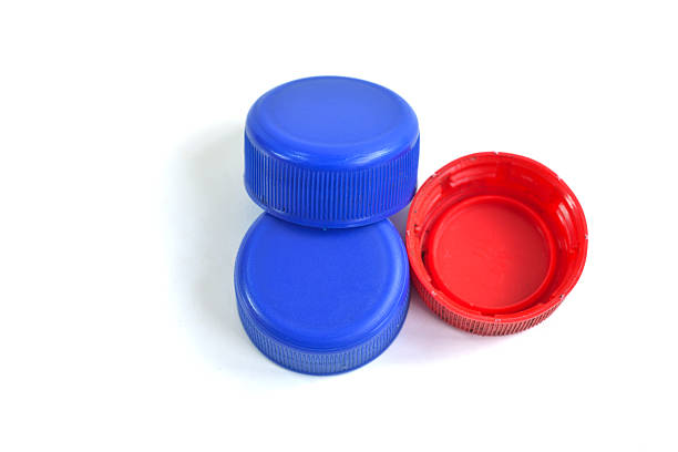 Close up of plastic bottle caps isolated on white background, concept of environmental protection, littering of environment. Selective focus.