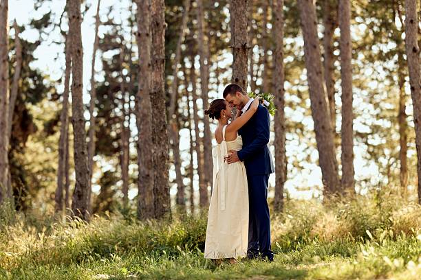 istock Romantic Wedding Couple Embracing in a Sunlit Forest Setting 2224705306