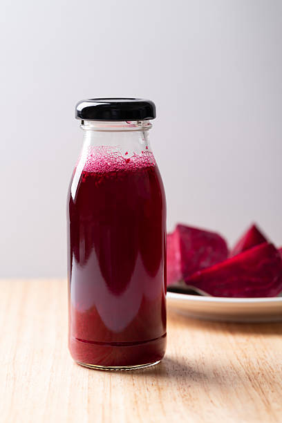 Fresh beetroot juice in bottle on wooden background