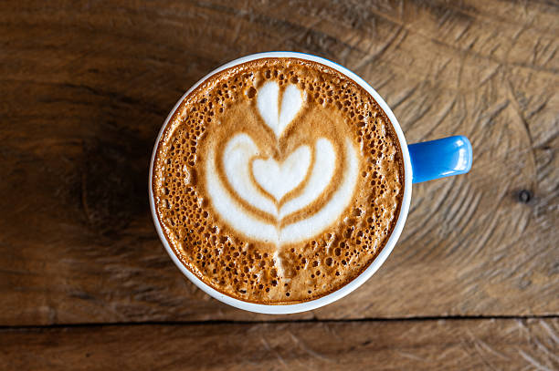 A hot cup of Cappuccino coffee serving on wooden table.