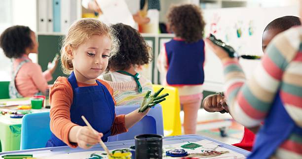istock Education, girl and students in classroom, painting and creative lesson with artwork project, learning and activity. Children, kids and development with mobility, growth and stationery in school 2224712698