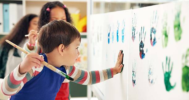 istock School, painting hands and children with paper for creative lesson, education and development. Kindergarten, classroom and kids learning with colors for fun activity, art project and motor skills 2224712699